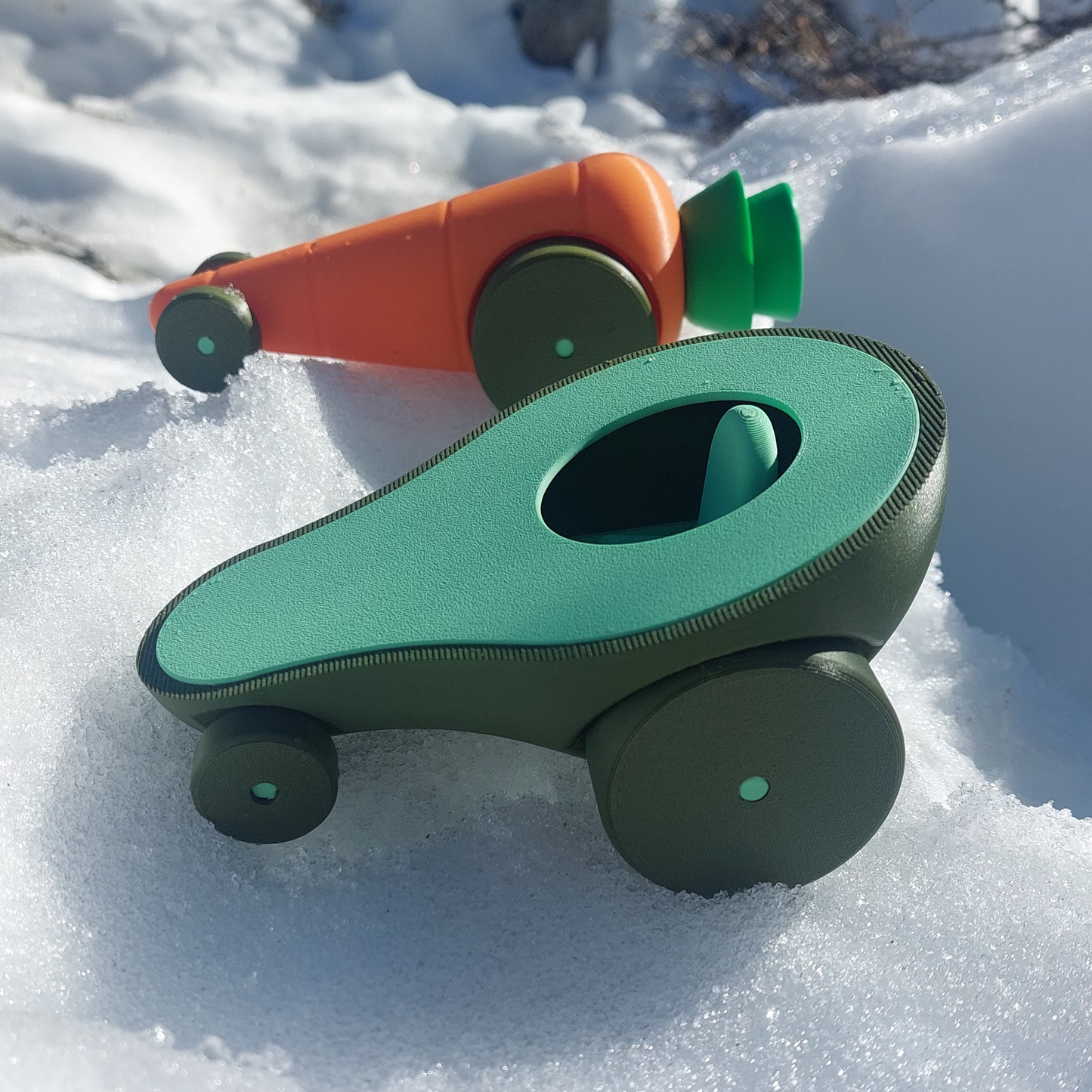 Pack de autitos de juguete con forma de vegtales (palta y zanahoria) el aire libre en la nieve. Fabricados con impresión 3D de calidad, producido en Chile