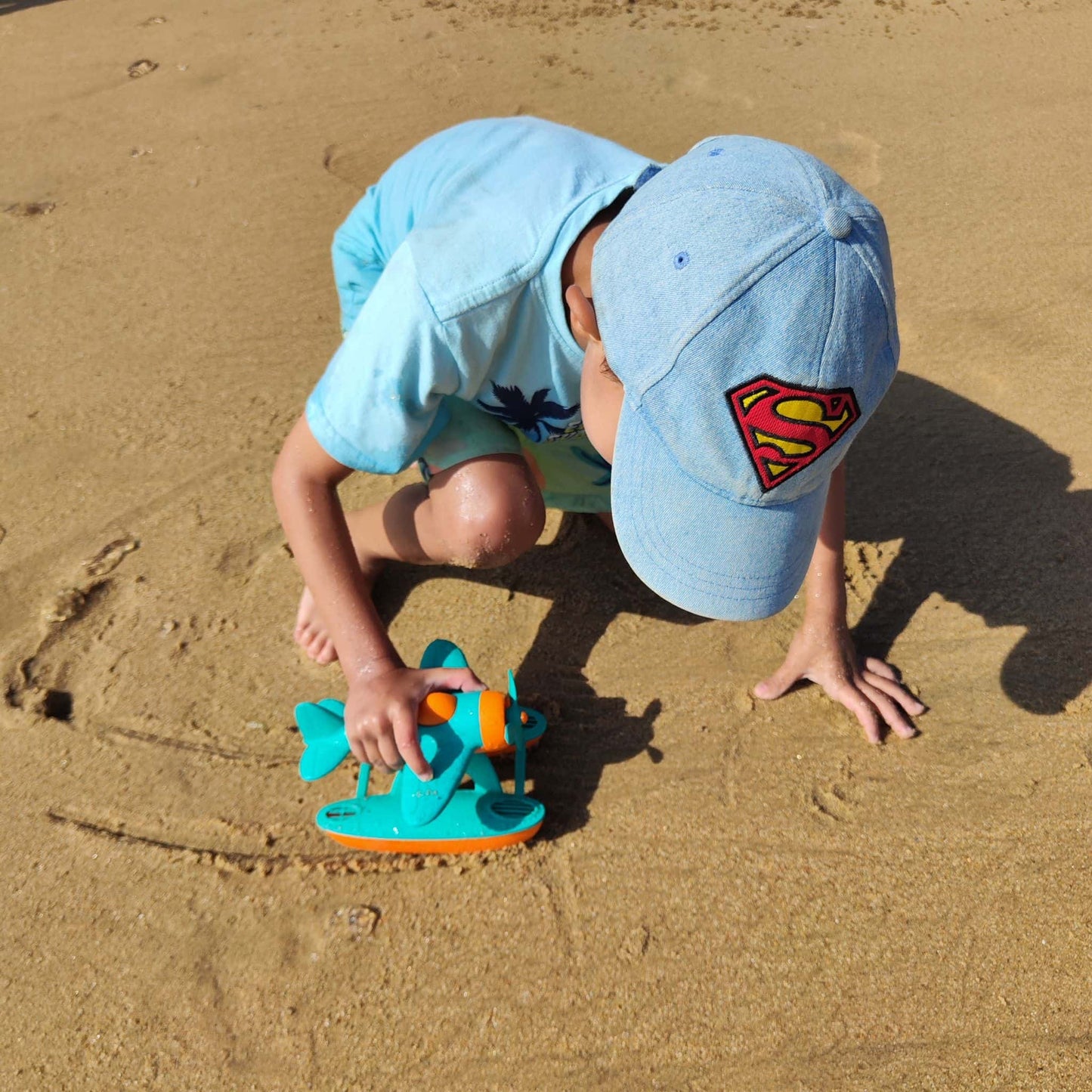 Niño jugando con hidroavión eco-friendly en la playa, fomentando la imaginación y coordinación
