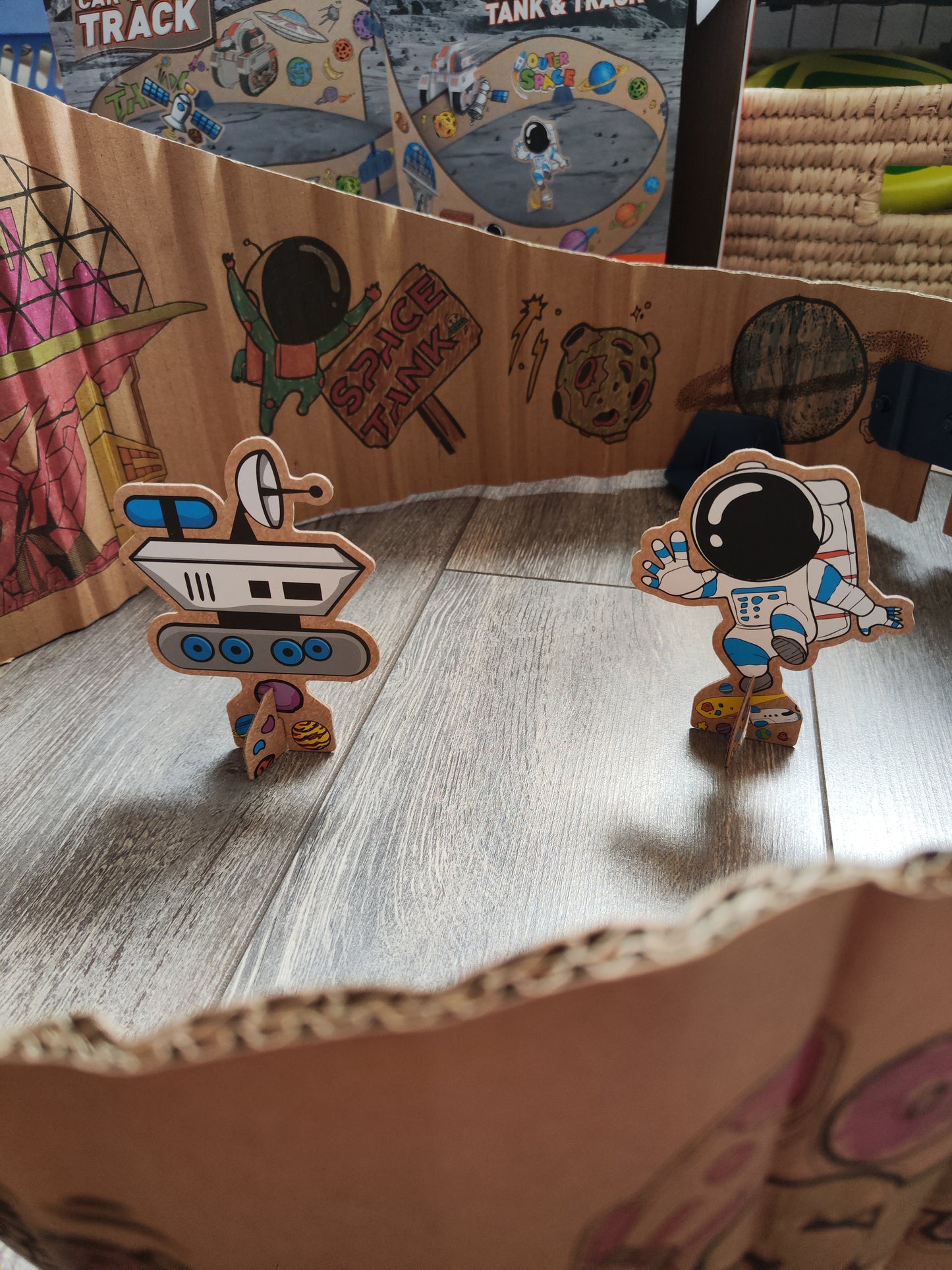 Detalle del ensamblaje de la pista espacial modular en cartón con sus figuras de astronauta y sonda espacial