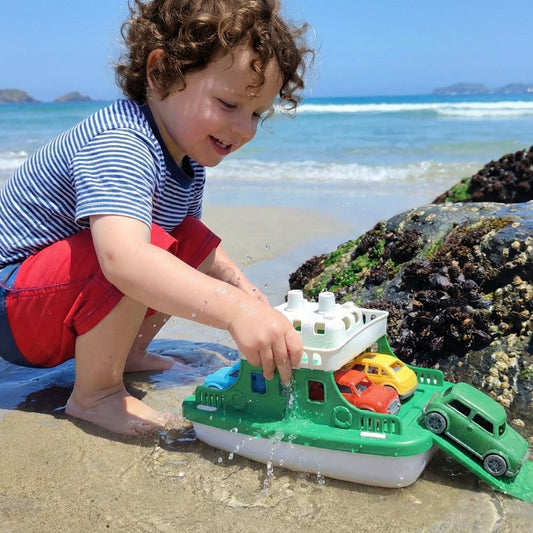 Niño jugando en la playa con el Ferry de plástico reciclable y 4 autitos