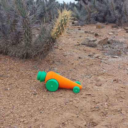 Auto de juguete con forma de zanahoria, al aire libre. Diseño divertido y ecológico, fabricado con impresión 3D