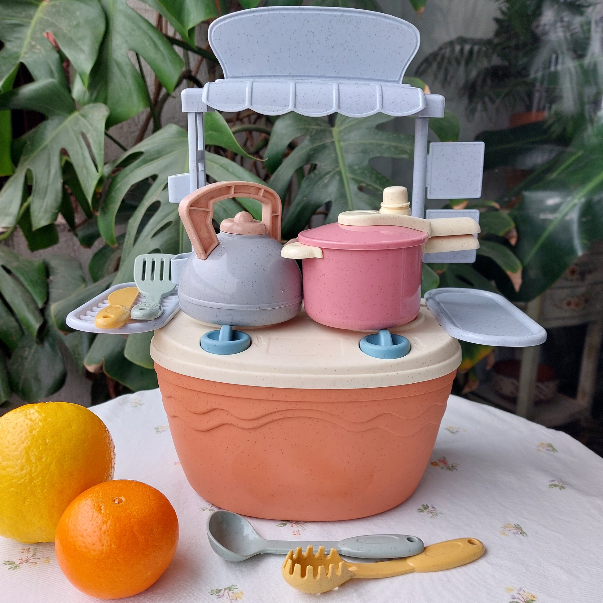 Set de cocina portátil de bioplástico de paja de trigo color coral claro, incluye hornilla, utensilios tetera y olla a presión. La hornilla funciona como caja de almacenamiento del juguete