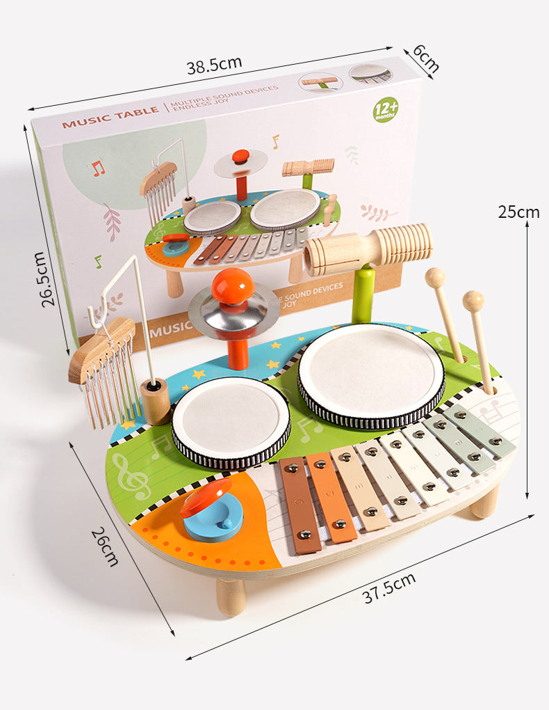 Set de percusión infantil 5‑en‑1 con instrumentos de madera eco‑friendly, 2 tambores, metalófono de 8 notas, platillo, güiro, carillón y 2 baquetas, con su empaque de fondo y sus medidas
